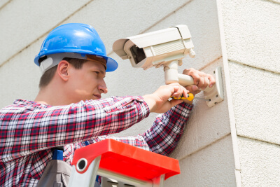 technician installing camera on the wall